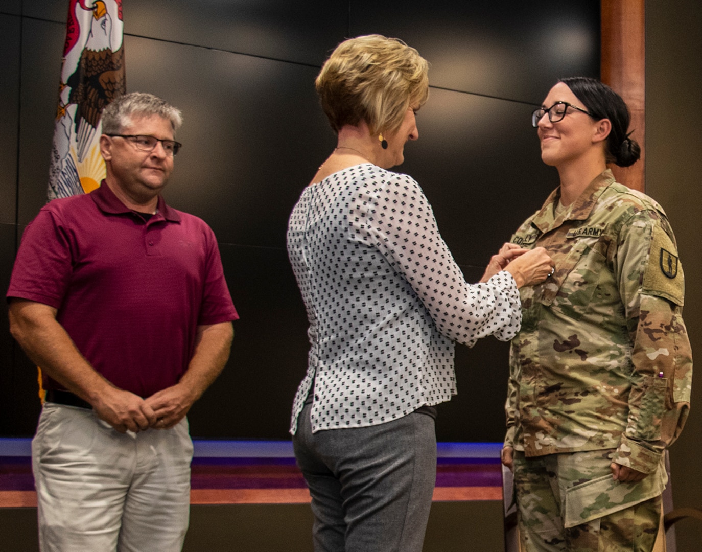 Newly promoted Sgt. 1st Class Erin Connelly’s sister, Candy Jansen, places Connelly’s new rank on her uniform during a promotion ceremony Sept. 4