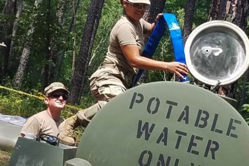 Service members fill water cells with clean water.