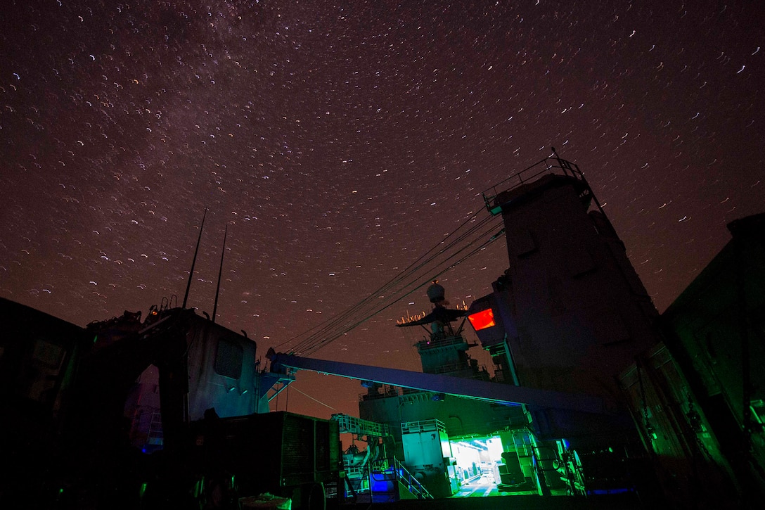 A ship transits a body of water at night.