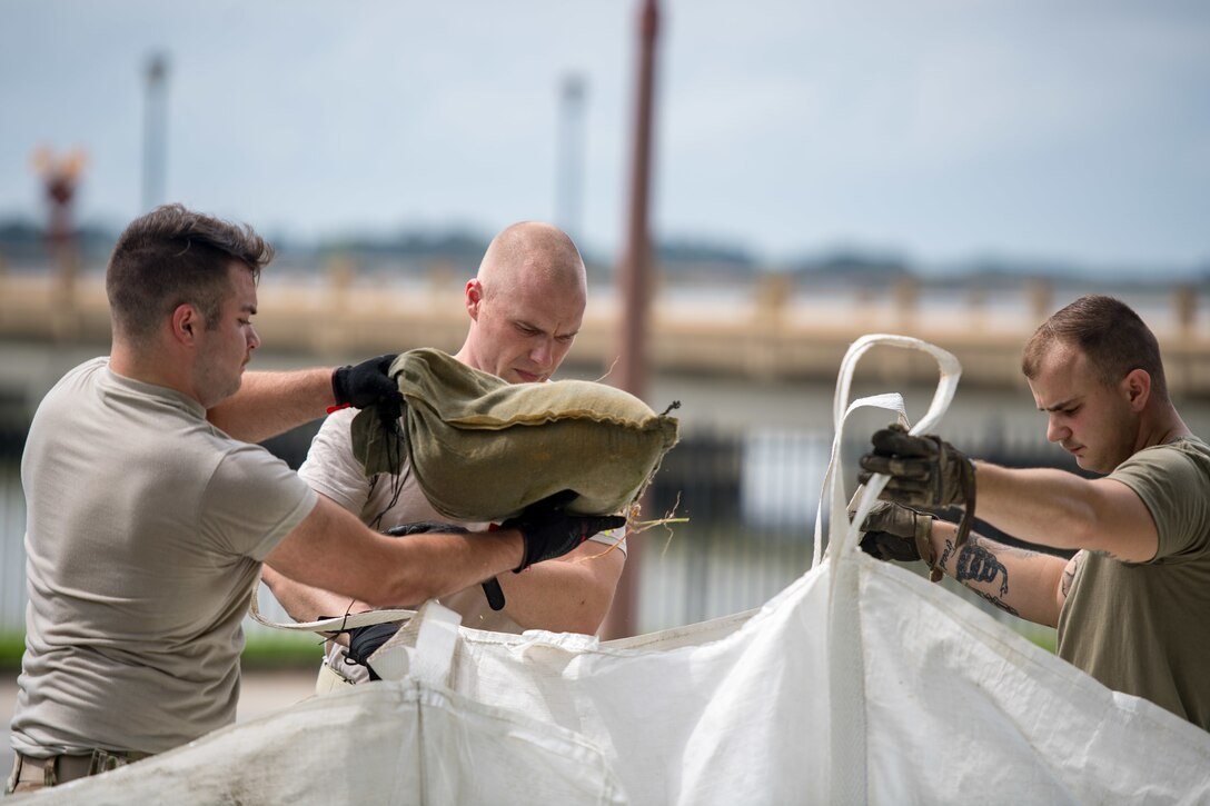 Airmen move sandbags in preparation for Hurricane Dorian
