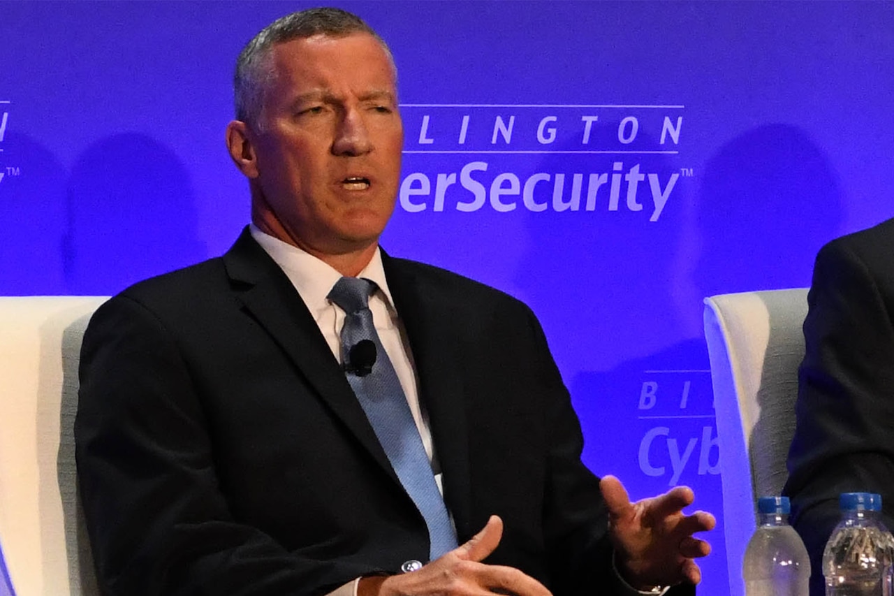 Seated man speaks during a panel discussion.