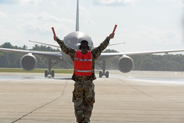 A crew chief assigned to the 157th Air Refueling Wing marshalls in the new KC-46A Pegasus on Aug. 8, 2019, at Pease Air National Guard Base, N.H. The plane is the most modern aerial refueler in the U.S. Air Force inventory. Members of the 931st Operations Group, consisting of members from the 924th Air Refueling Squadron and 18th Air Refueling Squadron, two of the Reserve flying squadrons at McConnell dedicated to the KC-46A Pegasus, delivered the first two KC-46s to the Airmen of the 157 ARW.  (U.S. Air Force photo by Senior Airmen Victoria Nelson)