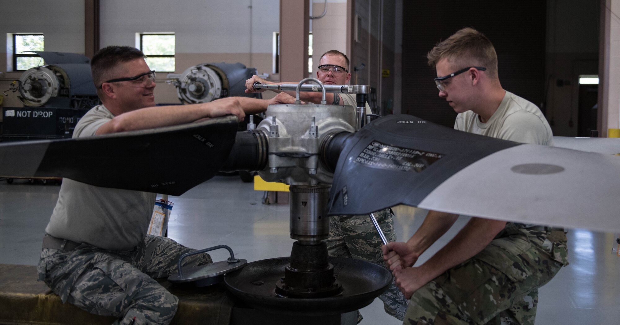 Tech. Sgt. Steve Lew (left), an aerospace propulsion technician, Master Sgt. Shawn Froehling (middle), a flight chief, and Senior Airman Sean Kenny (right), an aerospace propulsion technician, all assigned to the 910th Maintenance Squadron, are torqueing the bolts as a step in the assembly procedure, Aug. 11, 2019 at Youngstown Air Reserve Station.