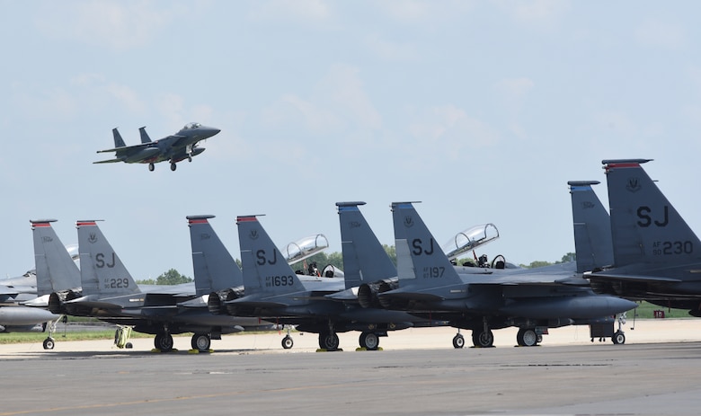 An F-15E Strike Eagle from the 4th Fighter Wing, Seymour-Johnson Air Force Base, North Carolina, on final approach to Tinker AFB, Oklahoma with other Strike Eagles parked in the foreground during a mass-relocation of vulnerable aircraft to escape Hurricane Dorian's path Sept. 4, 2019, Tinker AFB, Oklahoma. Team Tinker executed an existing agreement with Seymour-Johnson AFB, North Carolina and Warner-Robins AFB, Georgia to host fighters, tankers and reconnaissance aircraft far away from the devastating hurricane currently impacting the East Coast of the United States. (U.S. Air Force photo/Greg L. Davis)