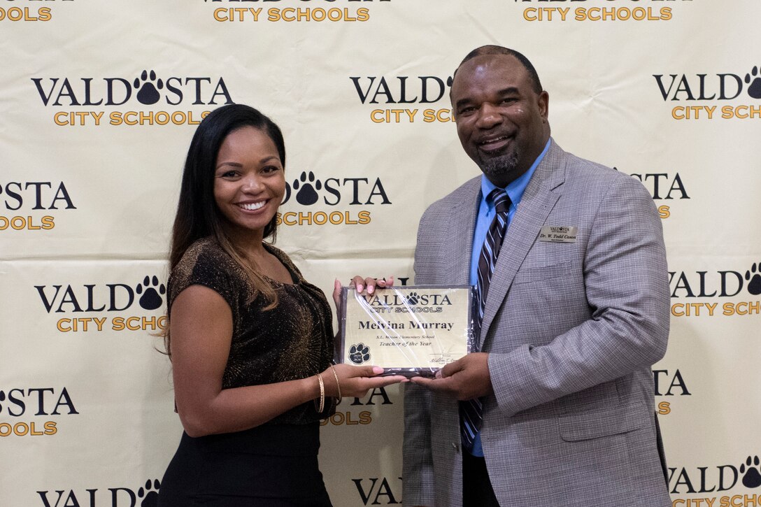 Dr. Todd Carson, right, Valdosta City Schools (VCS) superintendent, presents Melvina Murray, Teacher of the Year Award recipient and Team Moody spouse, with her plaque during the VCS 2019 Teacher of the Year Banquet, Sept. 5, 2019, at the Rainwater Conference Center, Valdosta, Ga. Melvina received the award for being the system’s educator who not only embodies her school’s core expectations of integrity first, respect for yourself and others, and excellence in all we do, but also consistently placed her service before herself. This year the VCS system named Murray as one of two recipients to recognize her hard work and dedication before the Murray family relocates to California mid-September. (U.S. Air Force photo by 2nd Lt. Kaylin P. Hankerson)