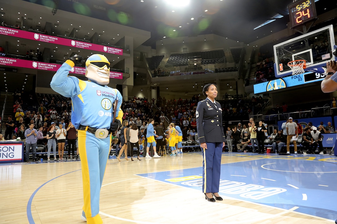 Sky Guy, the Women’s National Basketball Association’s Chicago Sky team mascot, prepares to present Army Reserve Master Sgt. Ebony Evans a plaque honoring her service during the Chicago Sky’s final home game, of the regular season, at the Wintrust Arena in Chicago, Illinois, September 1, 2019.