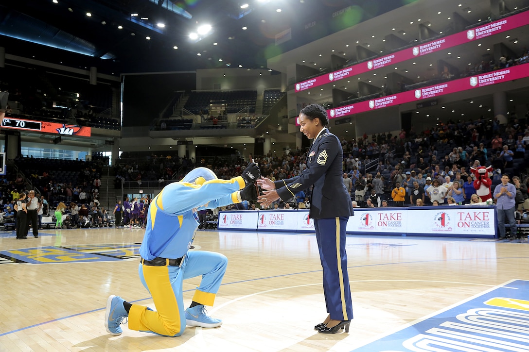 Sky Guy, the Women’s National Basketball Association’s Chicago Sky team mascot, presents a plaque to U.S. Army Reserve Master Sgt. Ebony Evans in front of thousands of spectators, honoring her service during the Chicago Sky’s final home game, of the regular season, at the Wintrust Arena in Chicago, Illinois, September 1, 2019.
