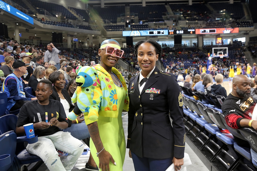 U.S. Army Reserve Master Sgt. Ebony Evans, right, pauses for a photo with a game spectator after she received an honor for her service during the Chicago Sky’s final home game, of the regular season, at the Wintrust Arena in Chicago, Illinois, September 1, 2019.