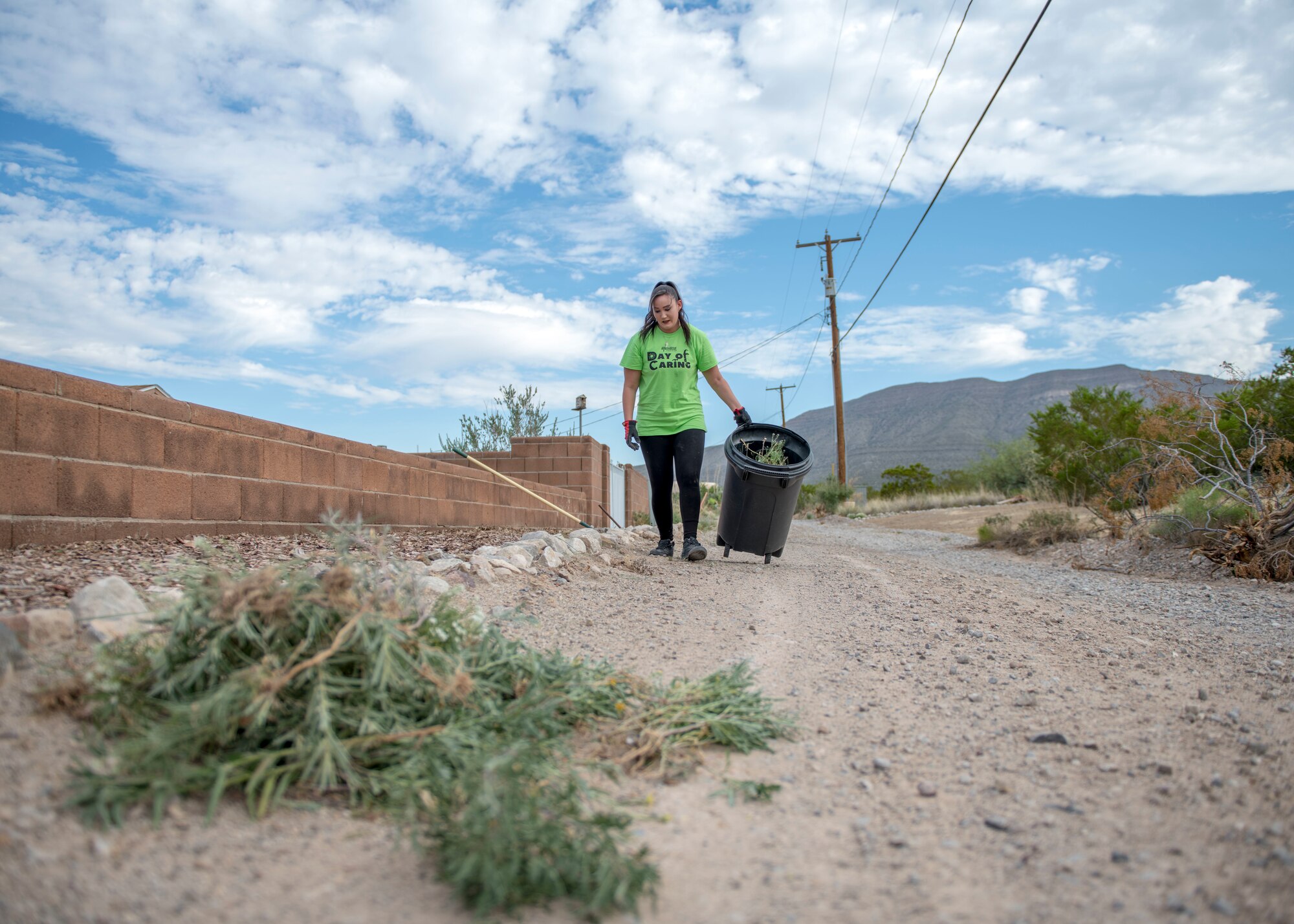 Tarah Martinez, a local community volunteer, throws away weeds, Sept. 6, 2019, at a residence in Alamogordo, N.M. Day of Caring volunteers performed various tasks, such as home repairs and yard work, at pre-determined job sites for individuals who are either unable to accomplish the tasks themselves or do not the resources to do so. (U.S. Air Force photo by Airman 1st Class Kindra Stewart)