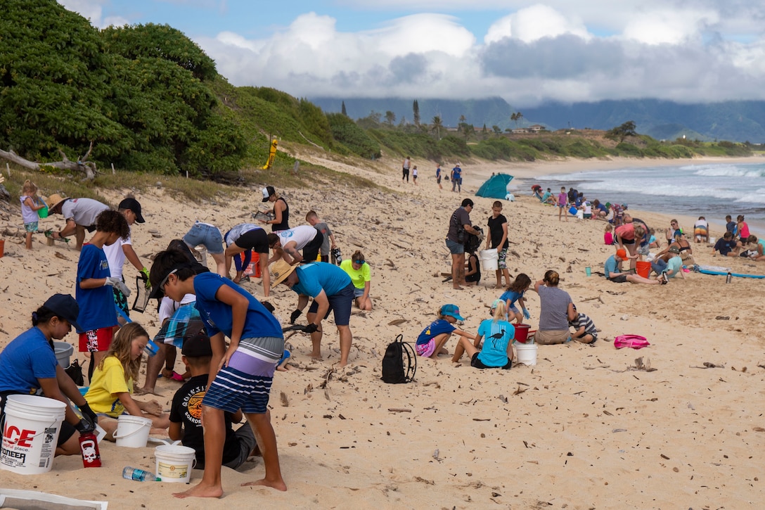 Parents and students with Mokapu Elementary take part in a beach clean-up at North Beach on Marine Corps Base Hawaii (MCBH), Sept.  1, 2019. The MCBH Environmental office hosted a beach clean up with the Mokapu Elementary School to remove trash and debris from North Beach. (U.S. Marine Corps photo by Cpl. Brendan Custer)