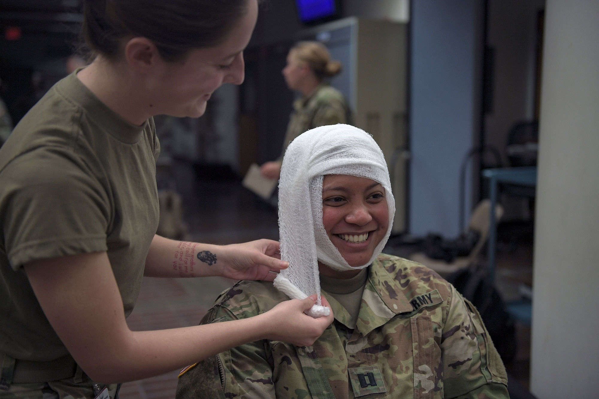 A soldier smiles as an Airman from the 51st Medical Group dresses her head wound during Operation Ascending Eagle, Aug. 28, 2019, at Osan Air Base, Republic of Korea. Air Force and Army medics jointly operated in the simulated large casualty training to enhance their aeromedical evacuation and patient transportation procedures. (U.S. Air Force photo by Staff Sgt. Greg Nash)
