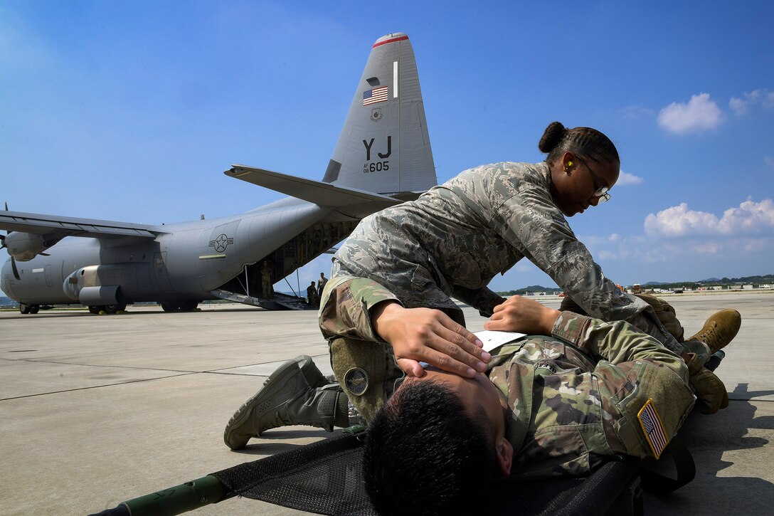 An Airman from the 51st Medical Group helps a soldier recover from injuries during Operation Ascending Eagle, Aug. 28, 2019, at Osan Air Base, Republic of Korea. Air Force and Army medics jointly operated in the simulated large casualty training to enhance their aeromedical evacuation and patient transportation procedures. (U.S. Air Force photo by Staff Sgt. Greg Nash)
