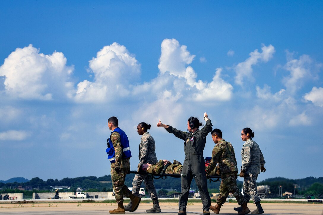 Airmen from the 51st Medical Group advance the flightline to transport a soldier from Camp Zama, Japan during Operation Ascending Eagle, Aug. 28, 2019, at Osan Air Base, Republic of Korea. Air Force and Army medics jointly operated in the simulated large casualty training to enhance their aeromedical evacuation and patient transportation procedures. (U.S. Air Force photo by Staff Sgt. Greg Nash)