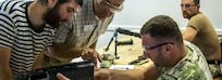Donald Bretch, an assisting instructor during the Small Arms Maintenance Course, observes Georgian soldiers and civilians as they reassemble the M240B weapons system in the Combined Arms Training Center in Vilseck, Germany, August 29, 2019