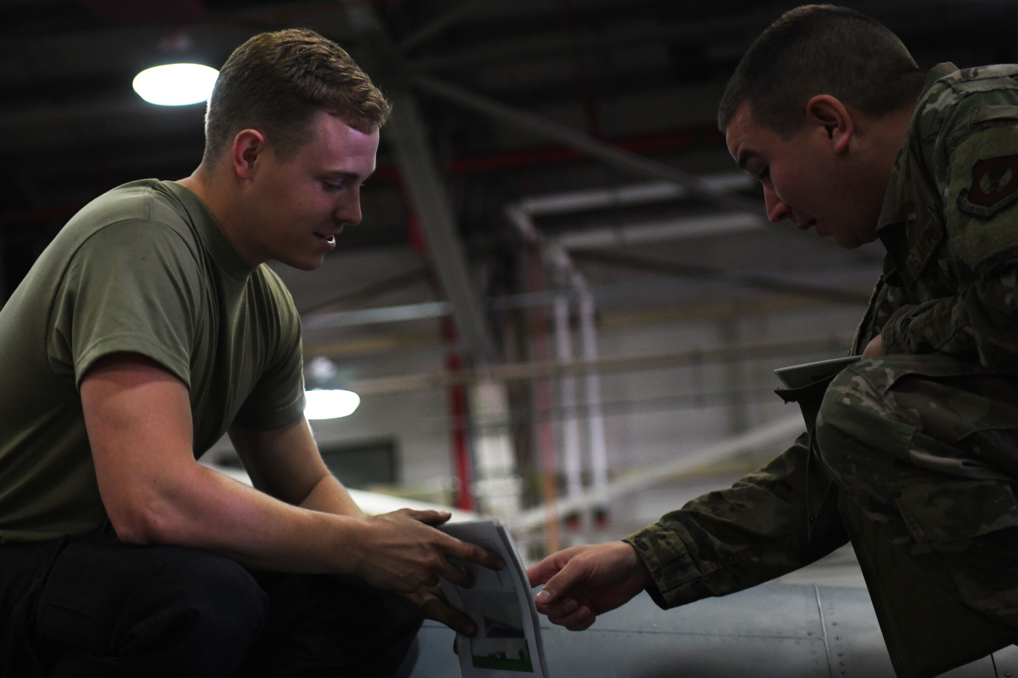 48th Equipment Maintenance Squadron crew chiefs discuss maintenance tasks during a phase inspection at Royal Air Force Lakenheath, England, Aug. 13, 2019. The 48th EMS innovators created a six-volume set of references to target specific critical areas of inspection and uncommon discrepancies. (U.S. Air Force photo by Airman 1st Class Shanice Williams-Jones)