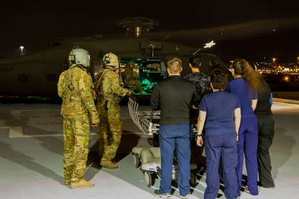 Sgt. First Class Jesse Turner, left, and Staff Sgt. Matt Oneill, flight medics assigned to 2nd General Aviation Support Battalion, 4th Aviation Regiment, 4th Infantry Division guide nurses from the emergency department to unload casualties from a UH-60 Black Hawk during a medical evacuation training scenario at University Medical Center, El Paso, Texas, September 4, 2019.