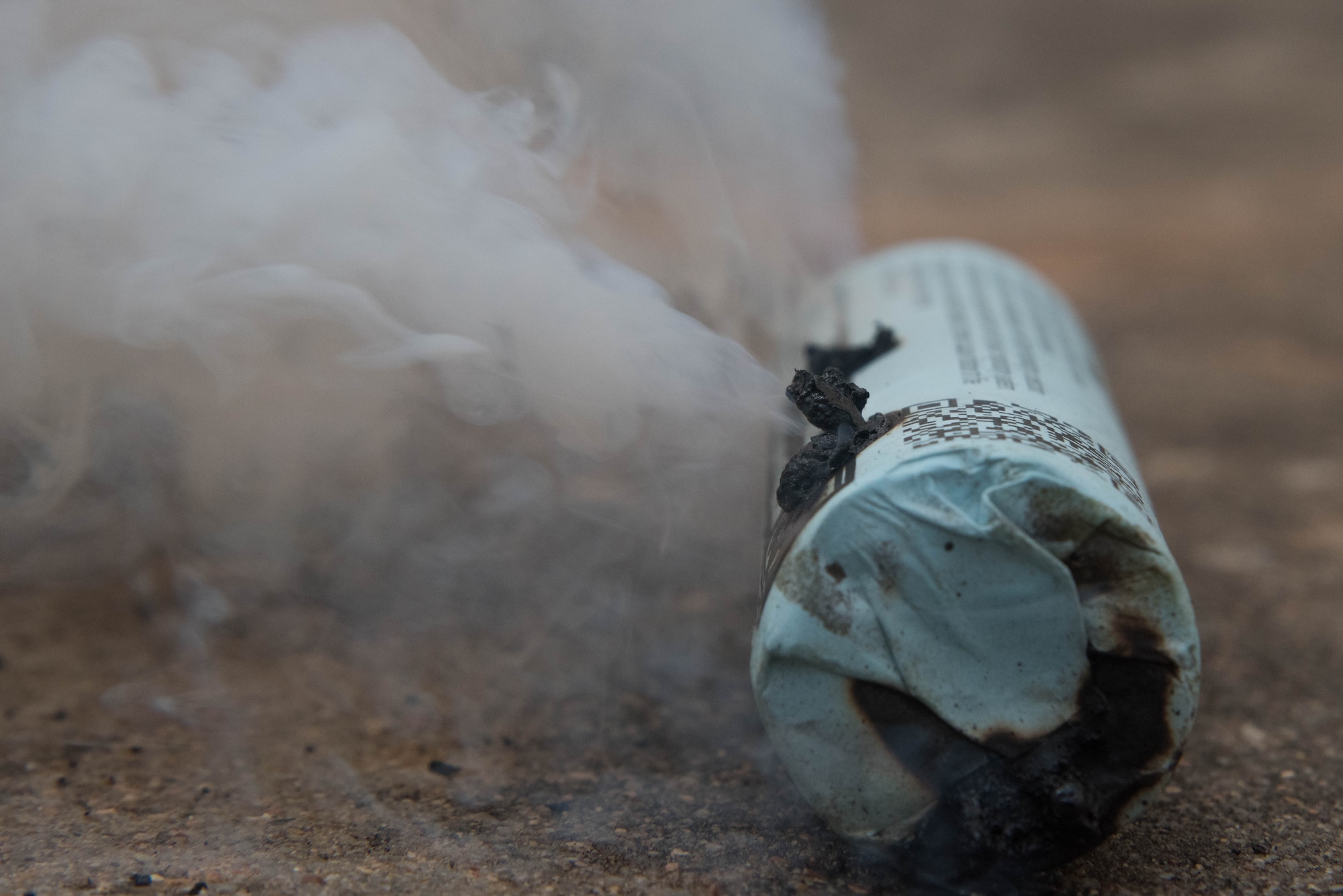 A 3C Smoke Candle releases a dense white smoke during a simulated chemical, biological, radiological and nuclear air assault Sept. 5, 2019, at McConnell Air Force Base, Kan. The smoke candle was used to replicate a chemical attack during CBRN training. Airmen participating in the training were tested on the actions they took during the simulated chemical attack. (U.S. Air Force photo by Airman 1st Class Marc A. Garcia)