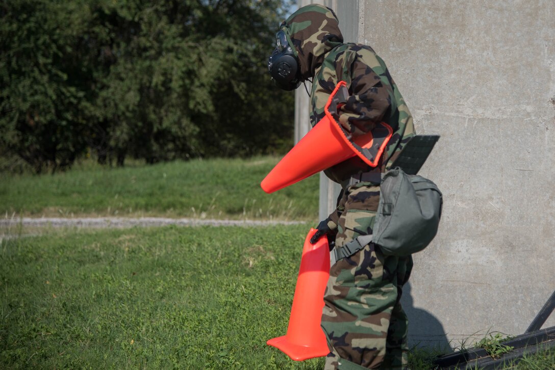 Airman 1st Class Sackwon Matthews, 22nd Force Support Squadron force management technician, sets a cordon around an unexploded ordnance during a chemical, biological, radiological and nuclear defense training Sept. 5, 2019, at McConnell Air Force Base, Kan. Cordons are set around the UXO to keep personnel at a safe distance if it happens to detonate. (U.S. Air Force photo by Airman 1st Class Marc A. Garcia)