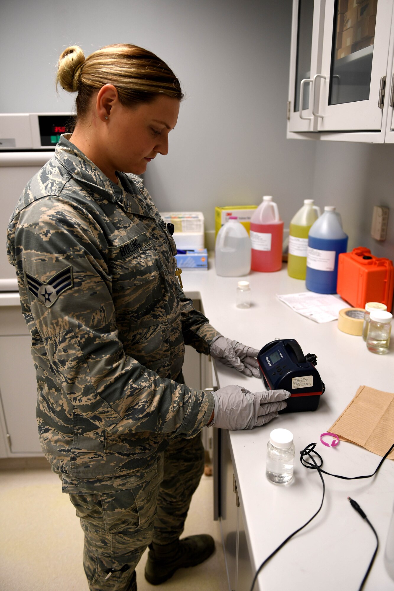 A woman in ABUs tests a water sample.