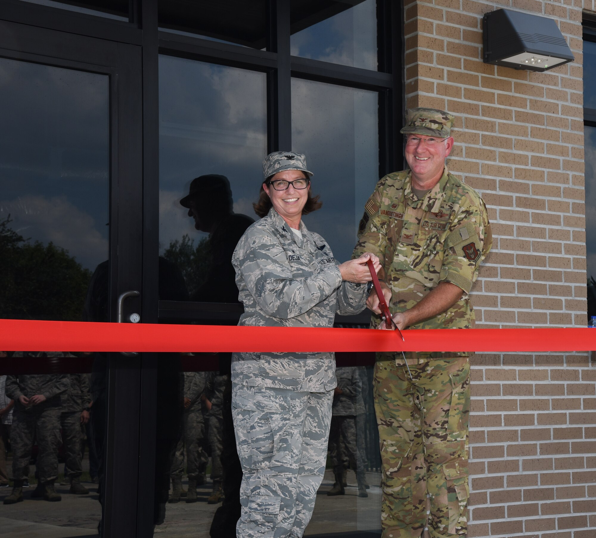 Col. Deborah A. Deja, 36th Aeromedical Evacuation Squadron commander, and Col. Jeffrey Van Dootingh, 403rd Wing commander, pose for a photo before cutting the ribbon in front of 36th AES's new building at Keesler Air Force Base, Miss., September 7, 2019. The 36th AES is responsible for the in-flight care of wounded service-members as they are transported to a medical facility equipped for critical situations (U.S. Air Force photo by Senior Airman Kristen L. Pittman).