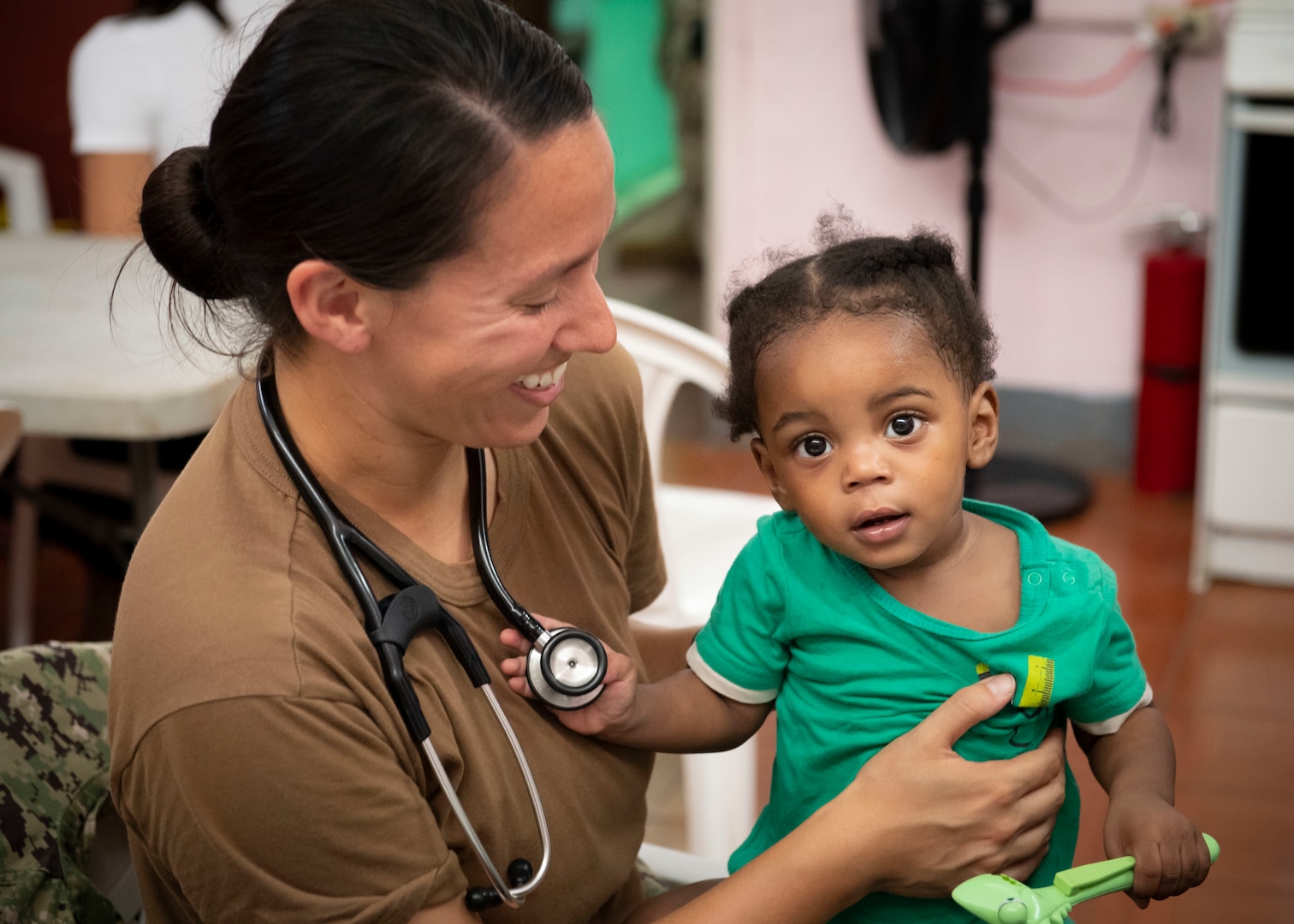 A doctor holds a small child.