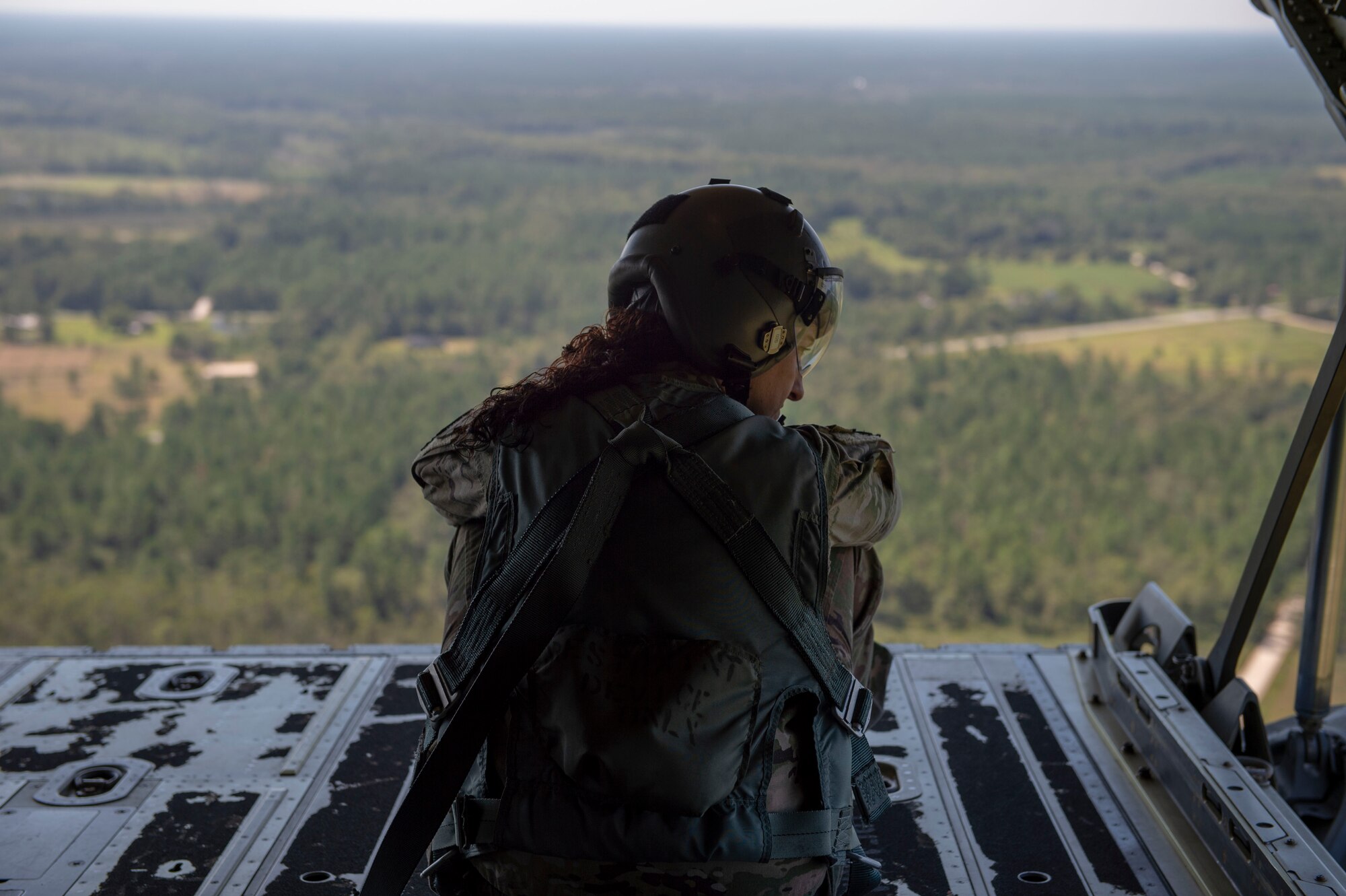 Tech. Sgt. Colleen McGahuey-Ramsey, 71st Rescue Squadron (RQS) loadmaster, looks out the back of an HC-130J Combat King II as it flies over south Georgia Sept. 6, 2019, at Moody Air Force Base, Ga. This was the first flight for the 71st RQS and the HC-130J Combat King II airframe to be operated by an all female aircrew. The 71st RQS provides rapidly deployable, expeditionary personnel recovery forces for theater commanders for contingency and crisis response operations worldwide. (U.S. Air Force photo by 2nd Lt. Kaylin P. Hankerson)