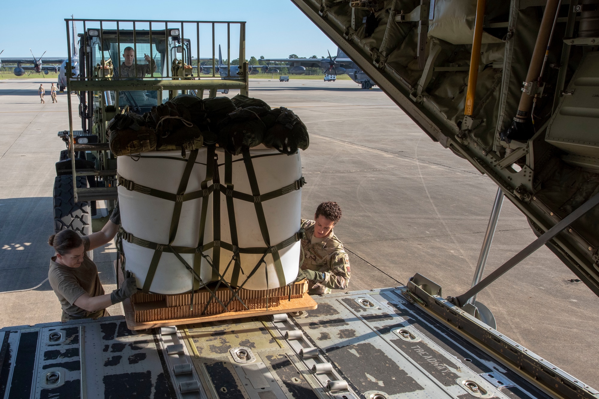 Senior Airman Rachel Bissonnette, left, and Tech. Sgt. Colleen McGahuey-Ramsey, right, both 71st Rescue Squadron (RQS) loadmasters, move a container delivery system on to the ramp of a HC-130J Combat King II before the airframe’s first flight to be operated by an all-female aircrew Sept. 6, 2019, at Moody Air Force Base, Ga. The 71st RQS provides rapidly deployable, expeditionary personnel recovery forces for contingency and crisis response operations worldwide. (U.S. Air Force photo by 2nd Lt. Kaylin P. Hankerson)