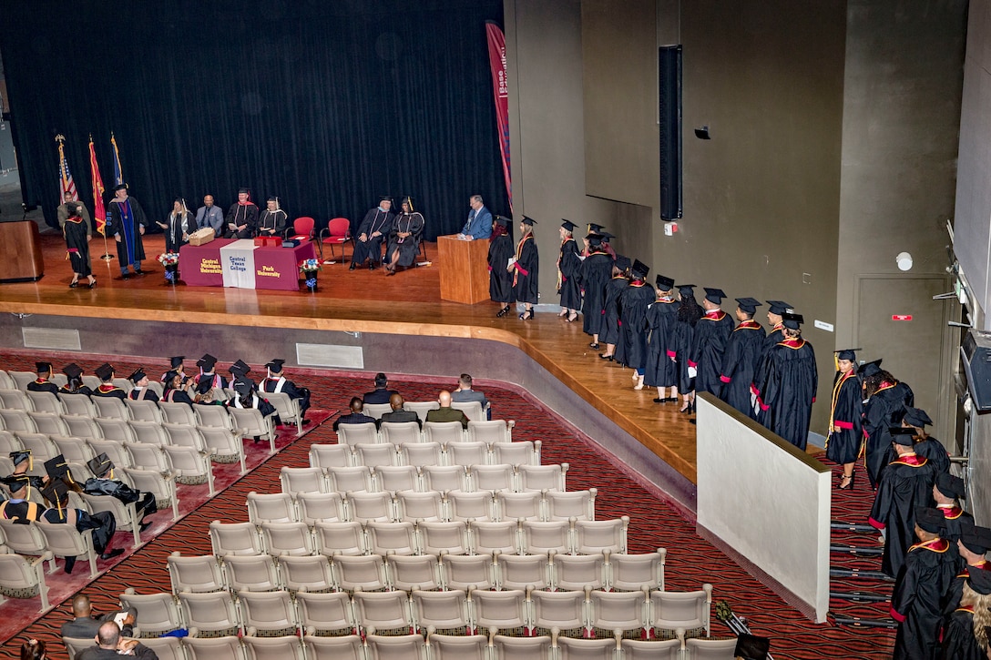 College graduates walk across the stage during the 2019 Base Education Center Commencement Ceremony at the Pendleton Base Theater and Training Center on Marine Corps Base Camp Pendleton, California, Sept. 6, 2019. The graduating class of 133 students earned 141 degrees from three of the colleges offered through the Base Education Center. (U.S. Marine Corps photo by Lance Cpl. Drake Nickels)
