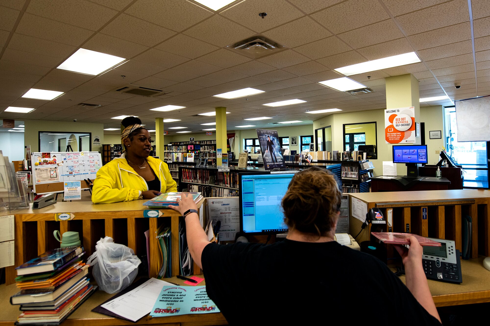 Katrina True, right, 23d Force Support Squadron library aid, checks books out to Candice Wilson, 23d Medical Group appointment clerk and military spouse, Sept. 6, 2019, at Moody Air Force Base, Ga. The Information Learning Center provides a means of morale and serves as the central hub for all informational and educational growth for Airmen and families. (U.S. Air Force photo by Senior Airman Erick Requadt)