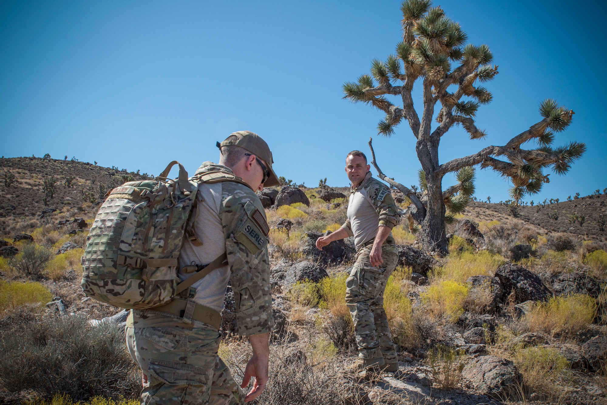 Tech. Sgt. Gary Roland and Tech. Sgt Jack Maher, survival, evasion, resistance, and escape (SERE) specialists assigned to 414th Combat Training Squadron (CTS), navigate a hill on the Nevada Test and Training Range, August 29, 2019.