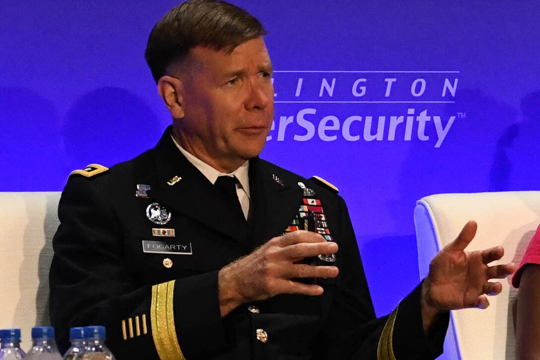 Man in uniform gestures with hands while speaking.