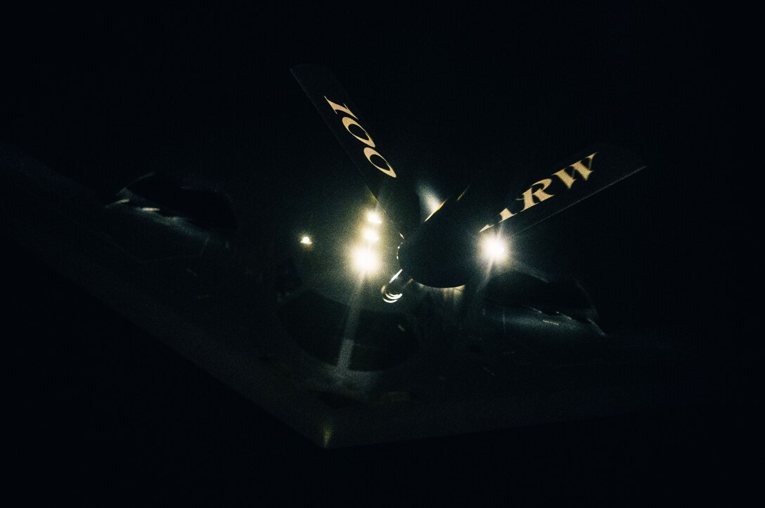 An aircraft receives fuel from another in the shadow of night.