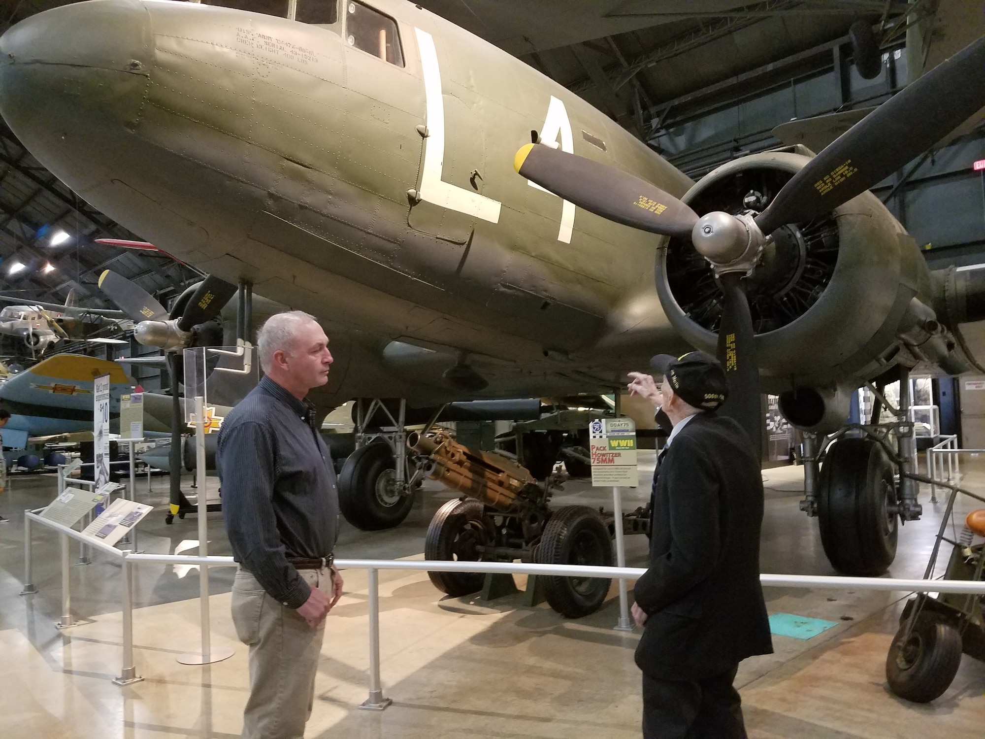 Air Force Research Laboratory Aerospace Systems Directorate employee Kevin Price (left) and World War II veteran Jim “Pee Wee” Martin look over the C-47 aircraft displayed at the National Museum of the United States Air Force on August 30, 2019. Price will accompany the 98-year-old Martin in September as he travels to the Netherlands to parachute into the region he helped liberate 75 years ago as part of Operation Market Garden. (U.S. Air Force Photo/Holly Jordan)