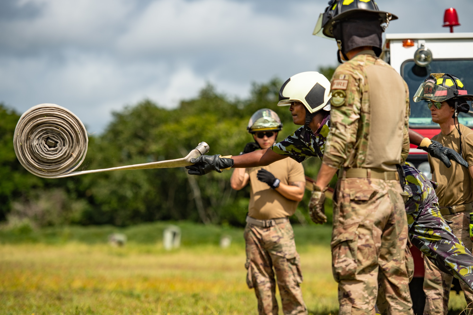 A Kenya Navy firefighter unravels a firehose during a training circuit at Manda Bay, Kenya, Aug. 29, 2019. The training, held by 475th Expeditionary Air Base Squadron firefighters, was designed to build upon the established partnership between the two nations by enforcing teamwork and endurance while enhancing technical proficiency. (U.S. Air Force photo by Staff Sgt. Devin Boyer)