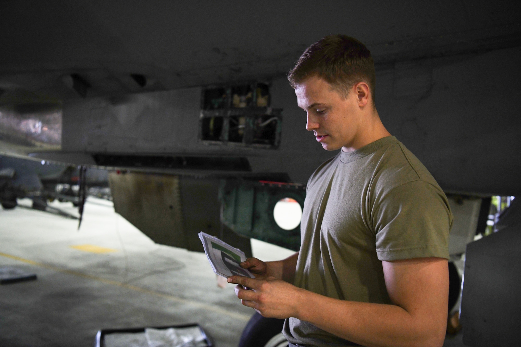 A 48th Equipment Maintenance Squadron crew chief consults an innovative new tool known as “The Bird Book” during a phase inspection at Royal Air Force Lakenheath, England, Aug. 13, 2019. The Bird Book is a collection of mechanical and troubleshooting processes for the F-15 aircraft assigned to RAF Lakenheath. (U.S. Air Force photo by Airman 1st Class Shanice Williams-Jones)