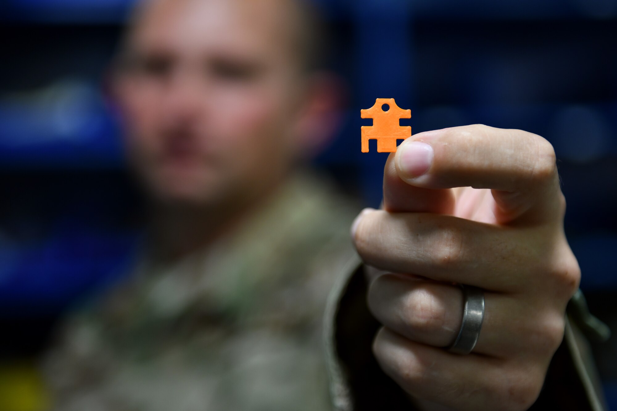 U.S. Air Force Tech. Sgt. Keith Boudreau, 31st Maintenance Group Air Force Repair Enhancement Program technician, holds a 3D printed spacer he created, Sep. 5, 2019, at Aviano Air Base, Italy. Spacers made by the AFREP technicians repaired 474 phones, saving the 31st Fighter Wing $106,176. (U.S. Air Force photo by Senior Airman Kevin Sommer Giron)