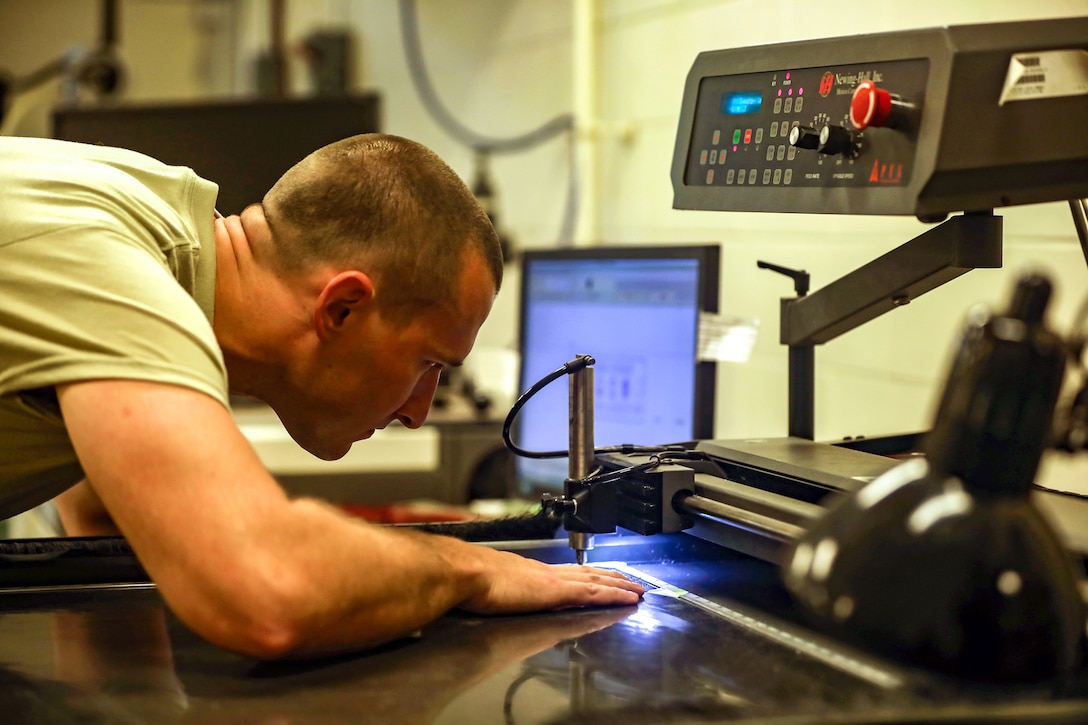 Tech. Sgt. Tyler Williams, 445th Maintenance Squadron, aircraft metals technician, operates an engraving machine at the fabrications and metal technologies shop Aug. 4, 2019.