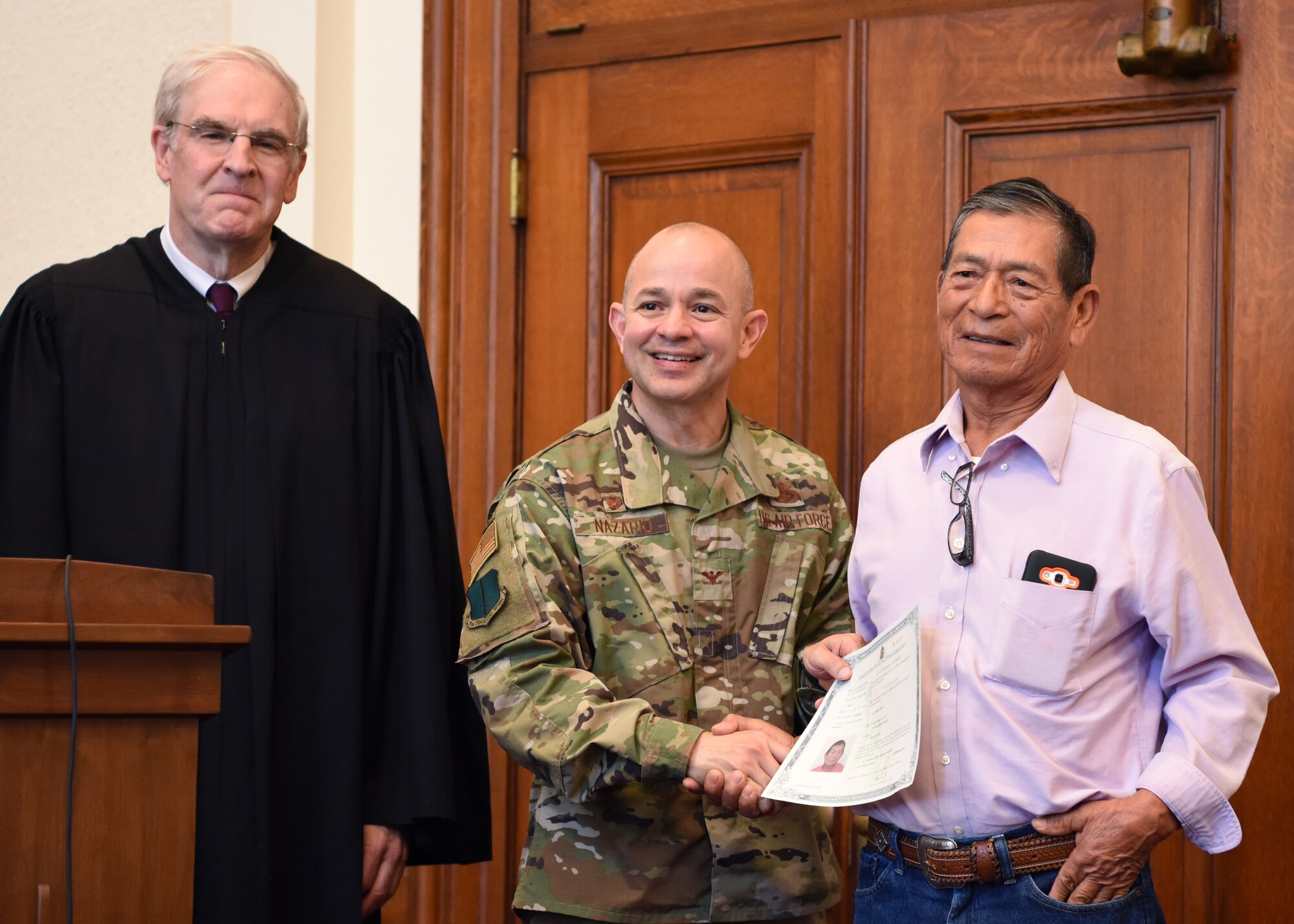 U.S. Air Force Col. Andres Nazario 17th Training Wing commander presents a certificate to Antonio Rojo Gonzalez, a new U.S. citizen at the Naturalization Ceremony in the O.C. Fisher Federal Building September 4, 2019. Rojo Gonzalez was the oldest member of the group at 77 years old. (U.S. Air Force photo by Airman 1st Class Ethan Sherwood)