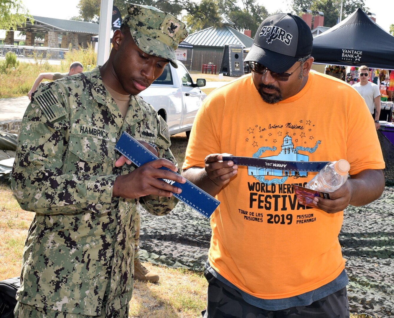 Petty Officer 2nd Class Mark Hambrick, assigned to Navy Recruiting District San Antonio, discusses the various rates of the Navy with an attendee of Mission Pachanga during the annual World Heritage Festival held at Mission Park Pavilion Sept. 7.