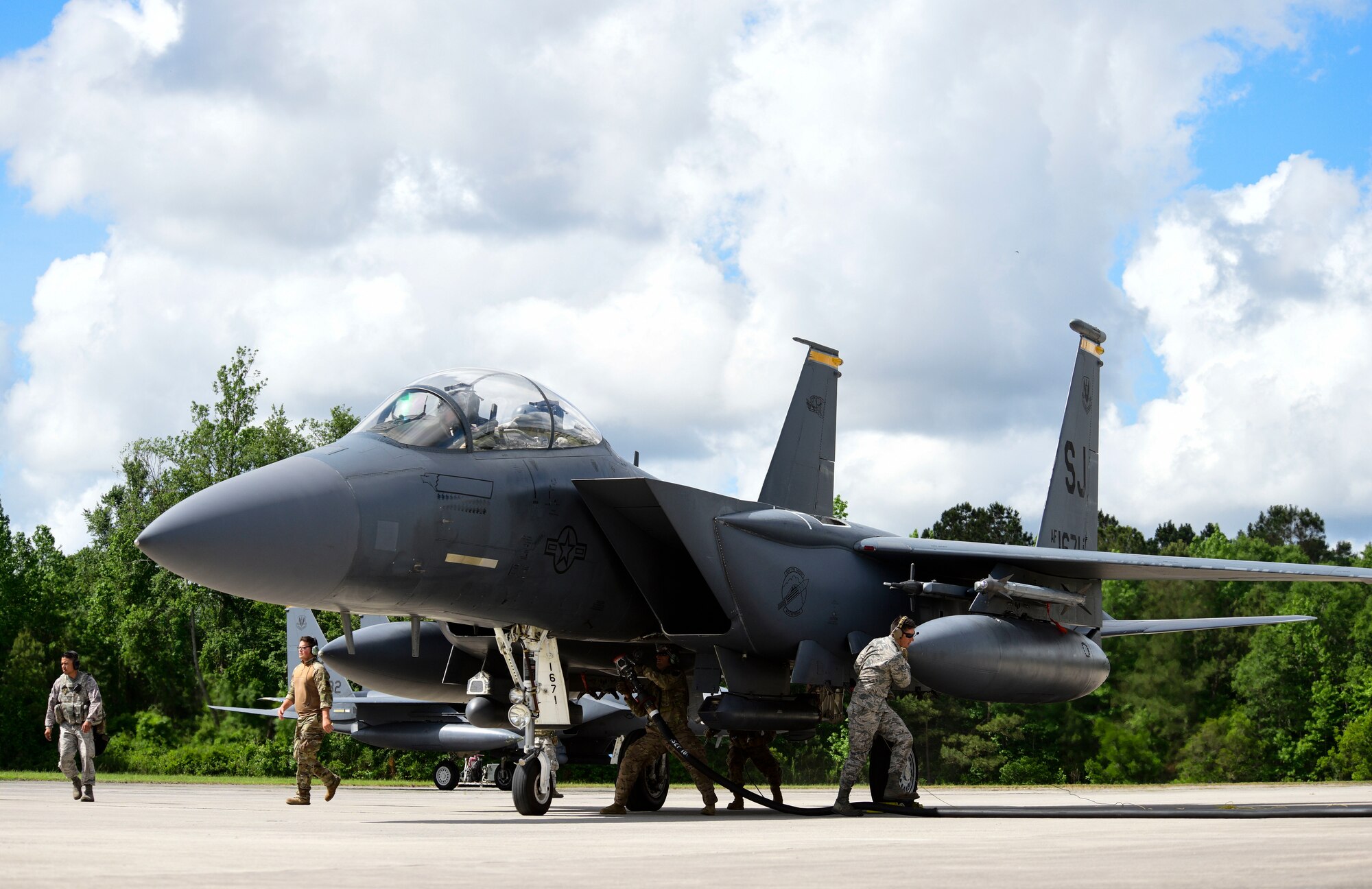 Airmen from multiple Air Force specialty codes perform a hot-pit refuel on an F-15 E Strike Eagle during the Combat Support Wing capstone, May 9, 2019, at Kinston Regional Jetport, North Carolina. A hot-pit is a term used to describe a jet being refueled on the ground while the engines are running. (U.S. Air Force photo by Senior Airman Kenneth Boyton)