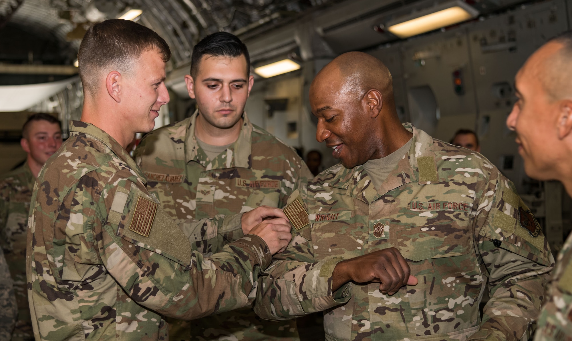 Senior Airman Dean Lemley, 736th Aircraft Maintenance Squadron C-17 dedicated crew chief, places a squadron patch on the sleeve of Chief Master Sgt. of the Air Force Kaleth O. Wright Sept. 4, 2019, at Dover Air Force Base, Del. Wright visited maintenance personnel and aircrew members on the Globemaster III. (U.S. Air Force photo by Roland Balik)