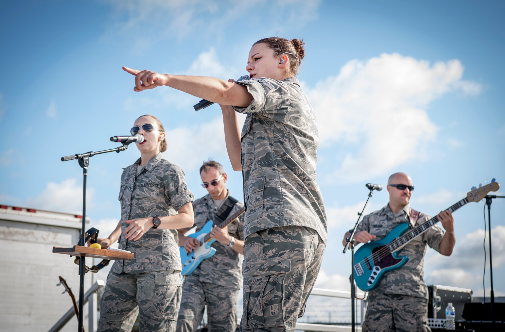 The Band of Mid-America Roots In Blue from Scott Air Force Base, Illinois, performs during Grissom’s Air & Space Expo at Grissom Air Reserve Base, Indiana, Sept. 7, 2019. In the photo A1C Dana Bowers, vocalist, is seen using her outgoing personality to entertain waiting lines with help from fellow band members Senior Airman Melissa Edgmon, vocalist/guitarist, Senior Airman Alberto Cosano, guitarist/director, and Airman 1st Class Dusty Carlson, bass guitarist. (U.S. Air Force photo/Master Sgt. Benjamin Mota)