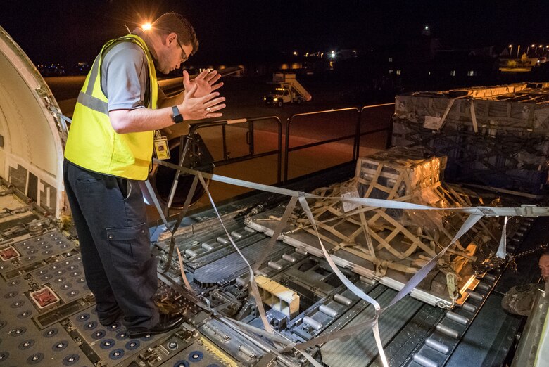 Brian McDonald, Air Transport International senior loadmaster, marshals a K-loader with five pallets driven by 436th Aerial Port Squadron ramp services personnel Sept. 8, 2019, at Dover Air Force Base, Del. The ATI aircraft, part of the Civil Reserve Air Fleet program, was contracted to transport cargo and 30 Team Dover personnel to Fairchild AFB, Wash., participating in Mobility Guardian 2019. “This mission is multidimensional and will provide a greater understanding of the commercial airlift capabilities and requirements across Air Mobility Command and the commercial airlift enterprise,” said Maj. Adam Crane, AMC Headquarters CRAF Branch Chief, Scott AFB, Ill. (U.S. Air Force photo by Roland Balik)
