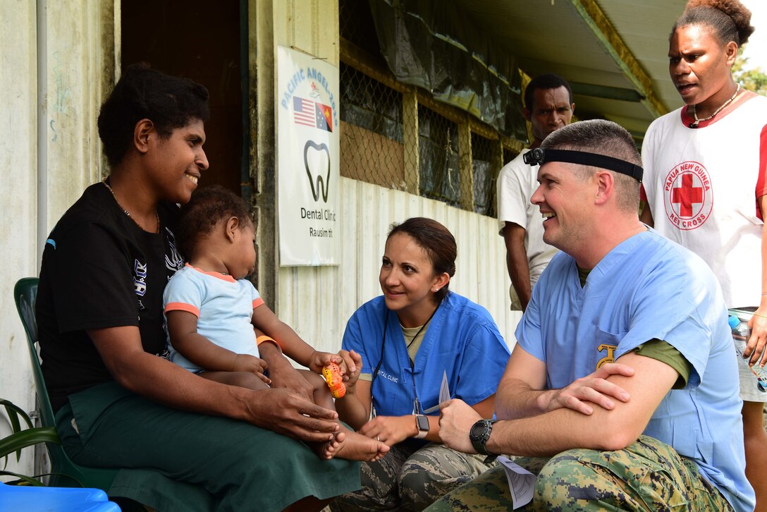 U.S. Navy LT Austin Stokes and U.S. Air Force Maj. Nicole Smith, both Pacific Angel 19-4 dentists, talk to a patient at the PAC ANGEL 19-4 health outreach site in Lae, Papua New Guinea Sept. 8, 2019. The health outreach site is comprised of five clinics including primary care, optometry, dental, physical therapy and pharmacy. (U.S. Air Force photo by Tech. Sgt. Jerilyn Quintanilla)