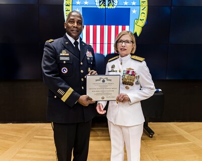 Man presents an award to a woman