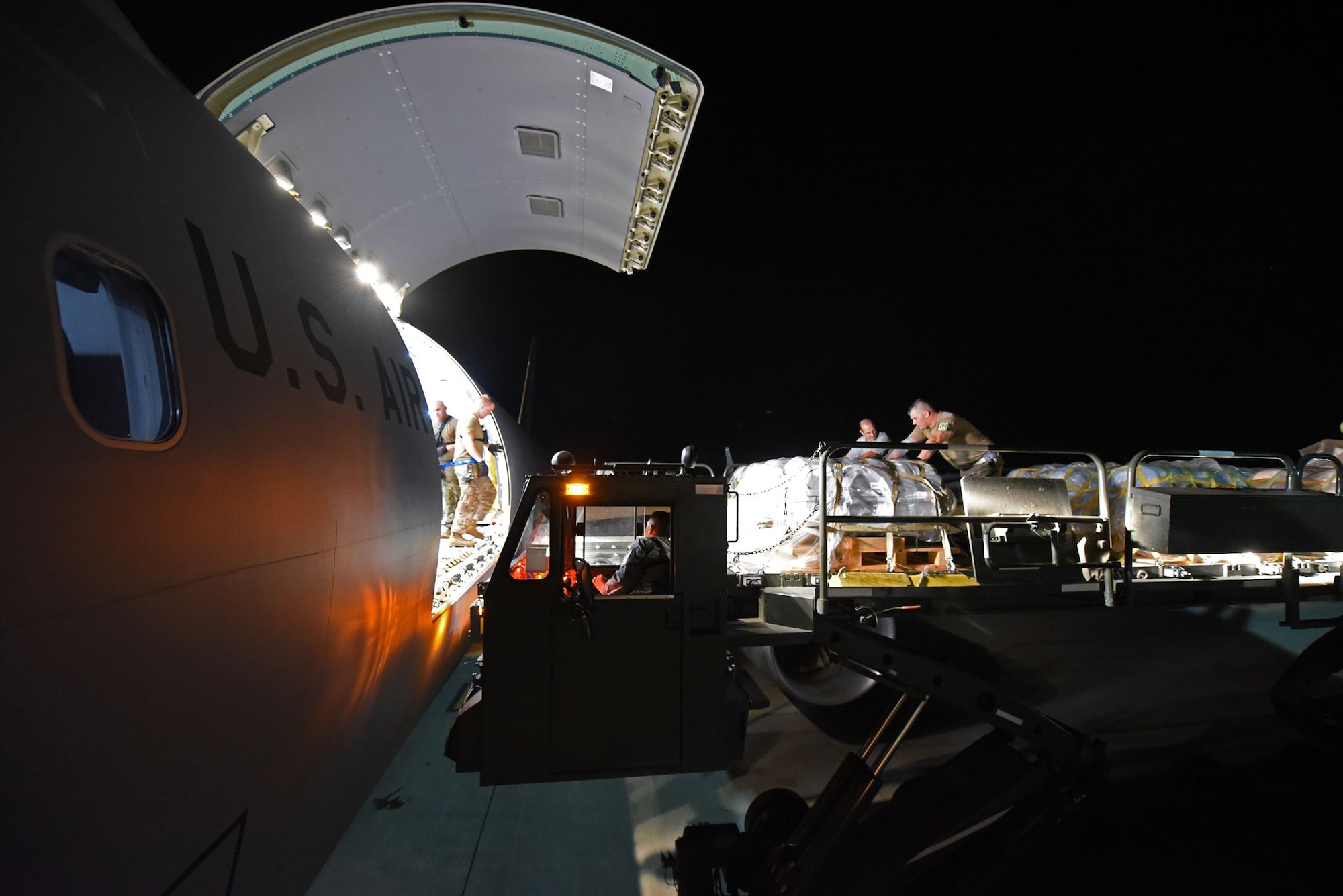 U.S. Airmen from the 60th Aerial Port Squadron from Travis Air Force Base, California, load cargo onto a McConnell AFB, Kansas, KC-46 Pegasus Aug. 21, 2019. The KC-46's stop at Travis entailed a late-night load of life rafts and other cargo for the U.S. Navy's USS Port Royal. (U.S. Air Force photo by Senior Airman Christian Conrad)