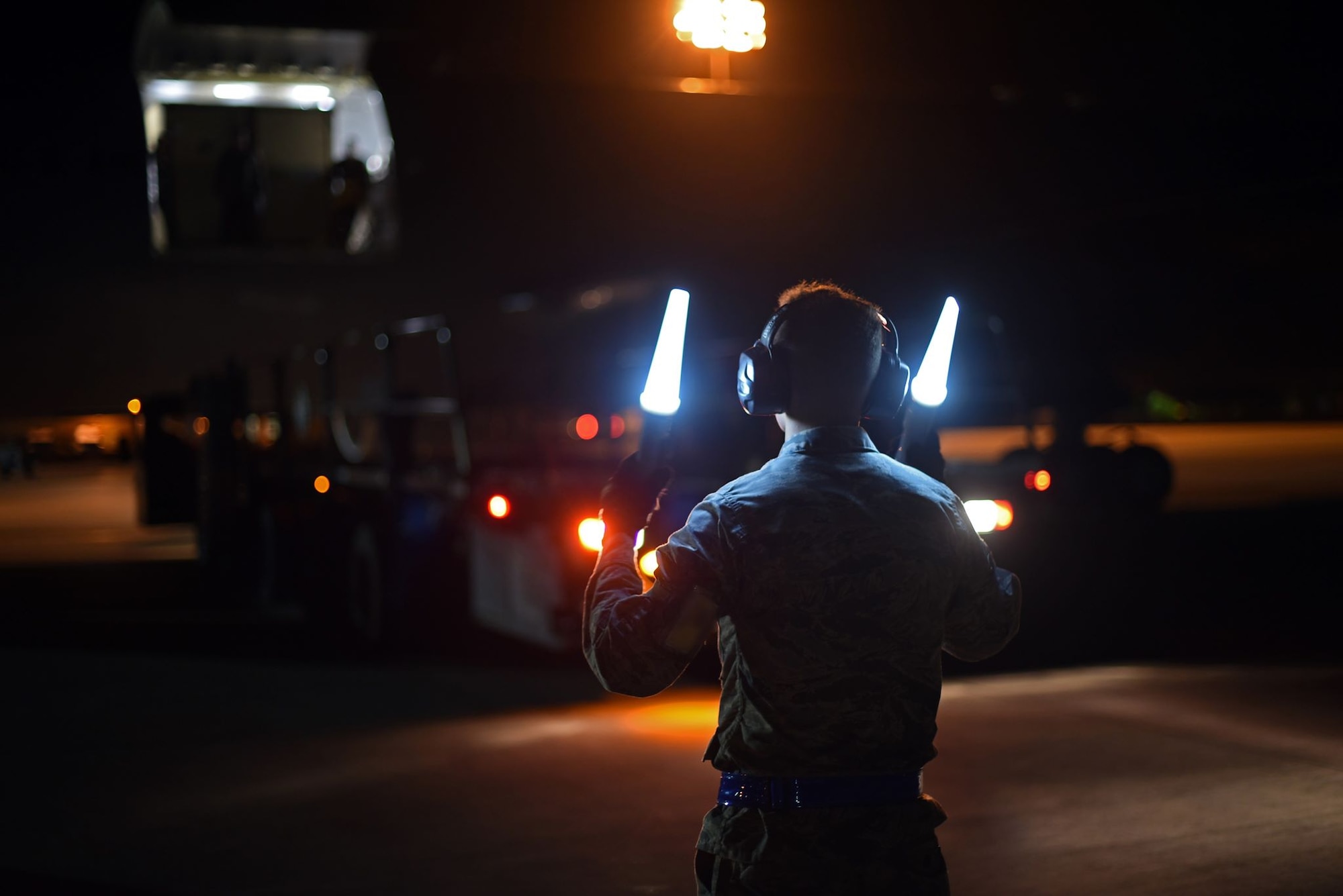U.S. Air Force Airman Ryan Richardsson, 60th Aerial Port Squadron air transportation journeyman, directs a cargo-loading vehicle away from a McConnell Air Force Base, Kansas, KC-46 Pegasus Aug. 21, 2019, at Travis AFB, California. Richardson was part of the Travis AFB crew who met the visiting KC-46 and which mission it was to load life rafts and other cargo onto the aircraft for the U.S. Navy's USS Port Royal. (U.S. Air Force photo by Senior Airman Christian Conrad)