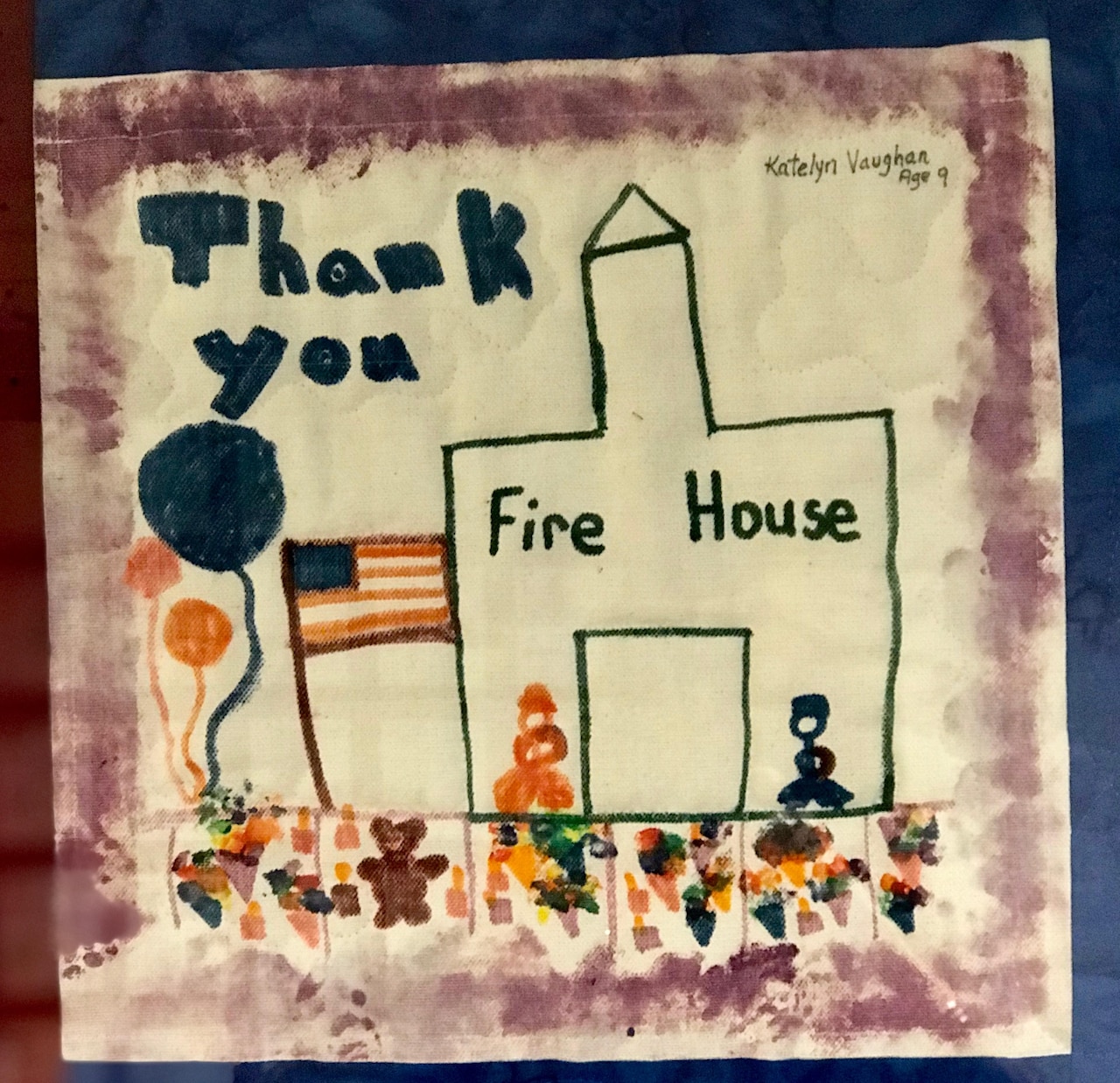 A poster made by children depicts a firehouse, and U.S. flag, firefighters and the words “thank you.”