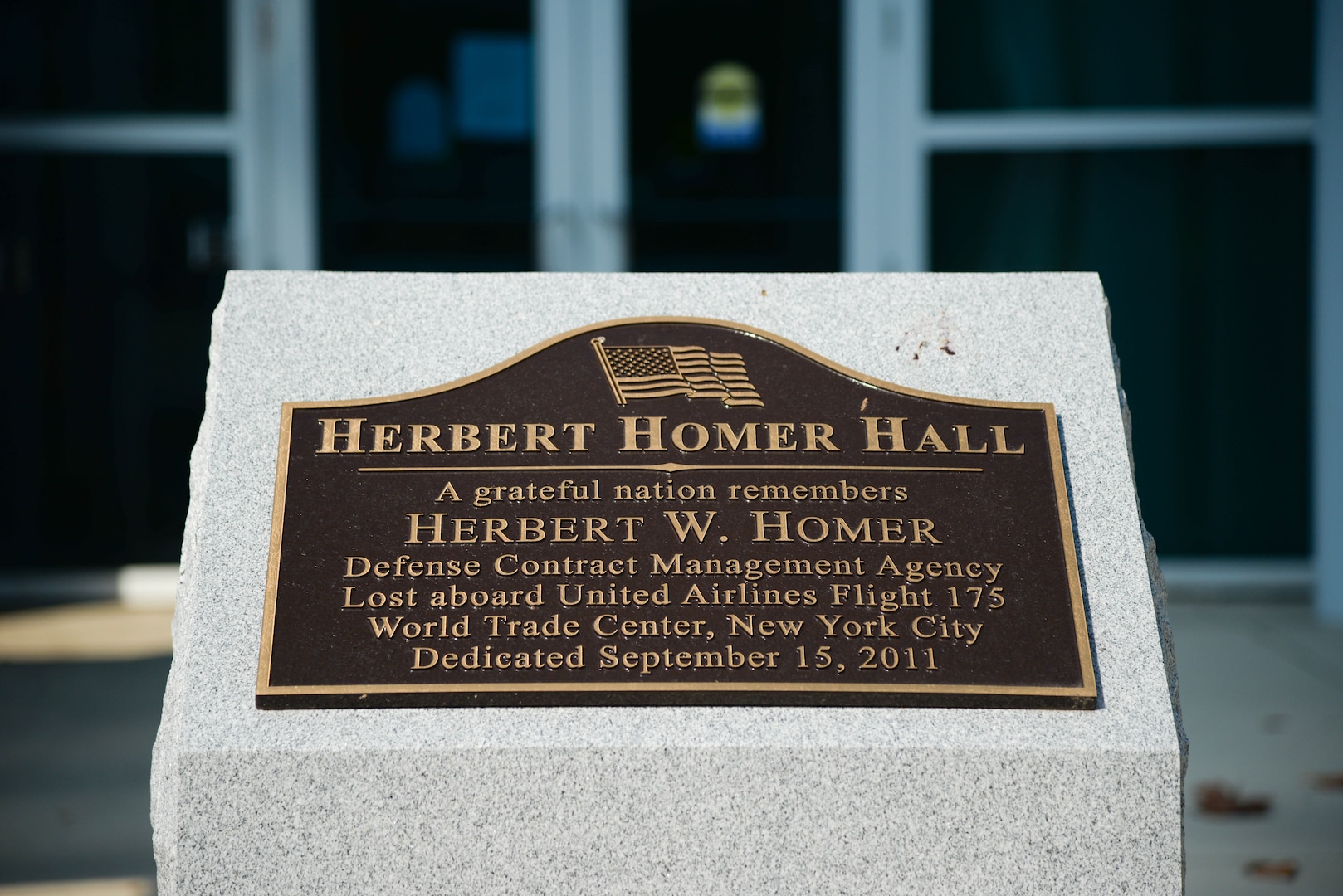 Brass plaque naming a large office building Herbert Homer Hall