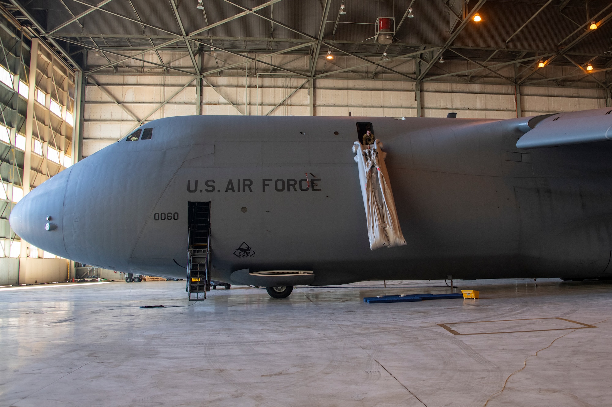 U.S. Air Force Staff Sgt. Kevin Robinson, 22nd Airlift Squadron loadmaster evaluator, deploys a C-5M Super Galaxy emergency escape slide Sept. 6, 2019, at Travis Air Force Base, California. Robinson wore a GoPro camera to record the process which will be used to develop a virtual reality training program on aircraft procedures. (U.S. Air Force photo by Heide Couch)